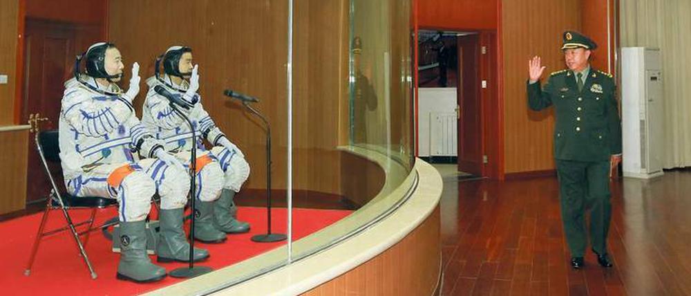 Macht’s gut. Fast beiläufig grüßt ein hoher Militärangehöriger die beiden Astronauten Jing Haipeng und Chen Dong, die keimfrei abgeschirmt auf eine Besprechung warten, in der sie letzte Instruktionen bekommen, was sie im All tun sollen.