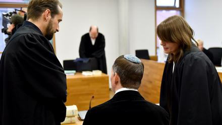 Der ehemalige Brandenburger Landtagsabgeordnete Peer Jürgens (Die Linke, M) unterhält sich im Amtsgericht in Potsdam vor Prozessbeginn mit seinen Anwälten Marlen Block und Norman Lenz. 