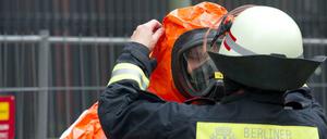 Einsatzkräfte der Feuerwehr in Schutzanzügen bereiten sich auf den Einsatz vor beim BND vor.