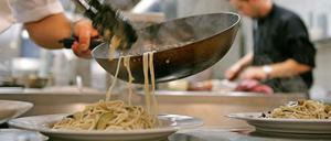 Es ist angerichtet: Köche beim Zubereiten von Speisen - für die Gäste.