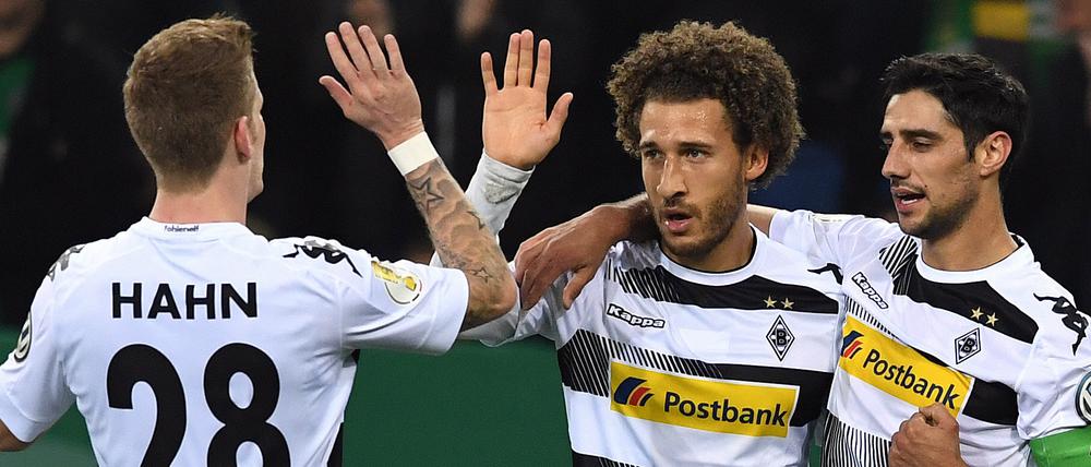 Andre Hahn (l-r), Lars Stindl und Torschütze Fabian Johnson aus Mönchengladbach feiern das 1:0.