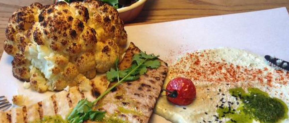 Das Essen im Bag Yard wird appetitlich arrangiert auf einem Holzbrett serviert. 