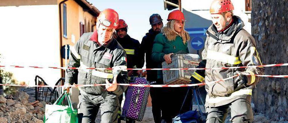 Feuerwehrleute helfen Menschen in Norcia, ihre Habseligkeiten zu retten.