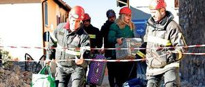 Feuerwehrleute helfen Menschen in Norcia, ihre Habseligkeiten zu retten. 