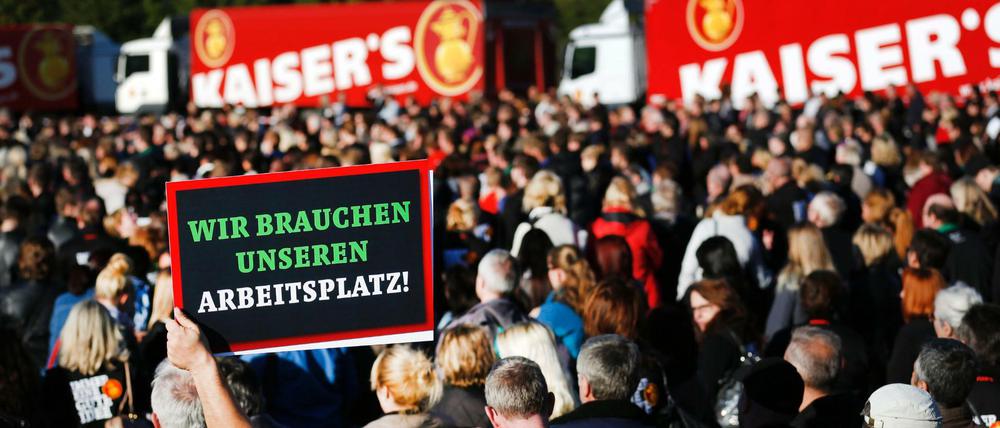 Ein Angestellter der Kaiser's Tengelmann GmbH hält ein Schild mit dem Schriftzug «Wir brauchen unseren Arbeitsplatz» bei einer Betriebsversammlung des Logistikzentrums am 05.10.2016 in Viersen hoch.