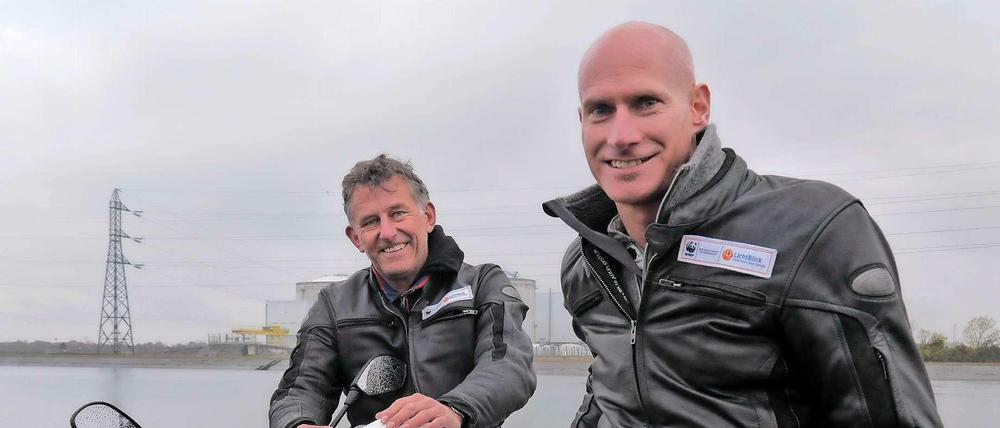 Jörn Ehlers und Frank Krippner mit ihrem Elektro-Motorrad vor dem Atomkraftwerk Fessenheim. 