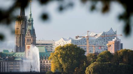 Die ersten Sonnenstrahlen erleuchten am 29.10.2016 das Rathaus, die Elbphilharmonie und die Alsterfontäne in Hamburg.