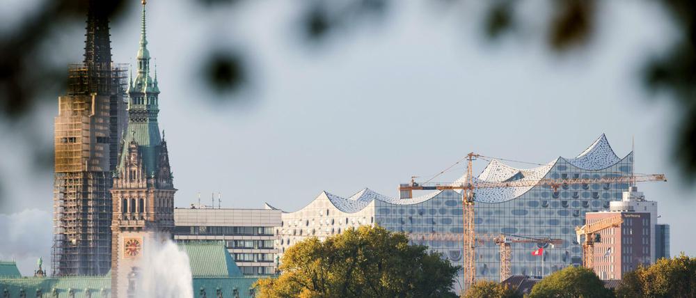 Die ersten Sonnenstrahlen erleuchten am 29.10.2016 das Rathaus, die Elbphilharmonie und die Alsterfontäne in Hamburg.