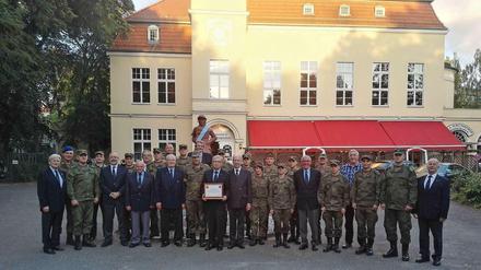 Gilde-Mitglieder mit deutschen und russischen Soldaten vor dem Hakenfelder Schützenhof.