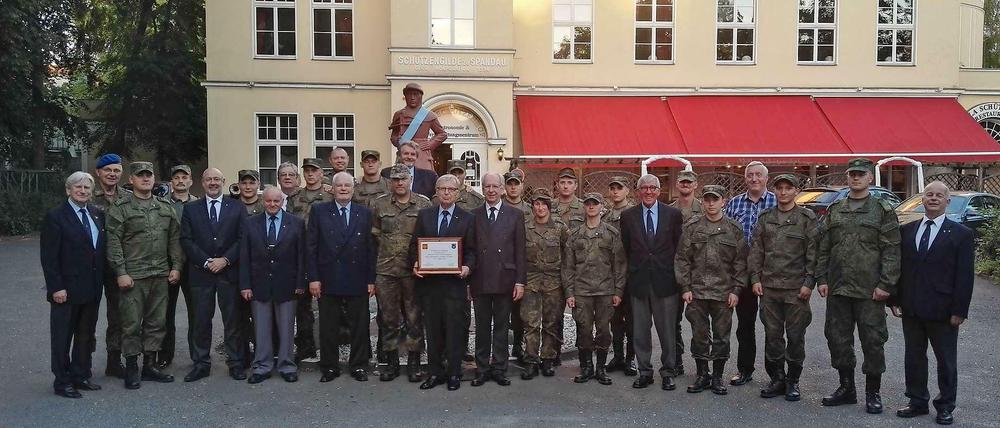 Gilde-Mitglieder mit deutschen und russischen Soldaten vor dem Hakenfelder Schützenhof.
