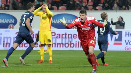 Torwart Rene Vollath (vorne) von Karlsruhe beschwert sich, während im Hintergrund Heidenheims Spieler den 2:1 Treffer feiern.