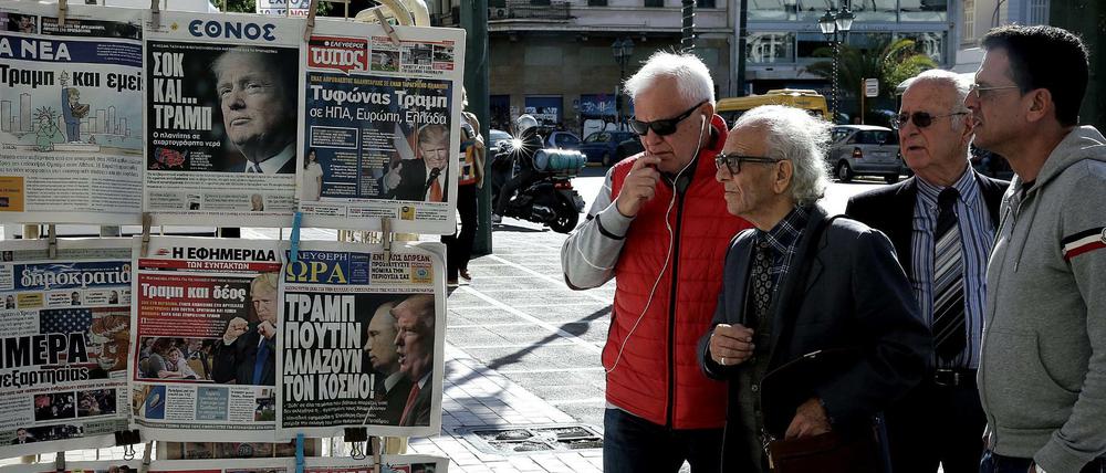 Menschen in Athen lesen die Schlagzeilen der Zeitungen nach der US-Wahl.