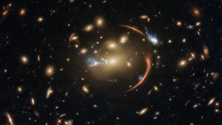 The centre of this image from the NASA/ESA Hubble Space Telescope is framed by the tell-tale arcs that result from strong gravitational lensing, a striking astronomical phenomenon which can warp, magnify, or even duplicate the appearance of distant galaxies.  Gravitational lensing occurs when light from a distant galaxy is subtly distorted by the gravitational pull of an intervening astronomical object. In this case, the relatively nearby galaxy cluster MACSJ0138.0-2155 has lensed a significantly more distant quiescent galaxy — a slumbering giant known as MRG-M0138 which has run out of the gas required to form new stars and is located 10 billion light years away. Astronomers can use gravitational lensing as a natural magnifying glass, allowing them to inspect objects like distant quiescent galaxies which would usually be too difficult for even Hubble to resolve. This image was made using observations from eight different infrared filters spread across two of Hubble’s most advanced astronomical instruments: the Advanced Camera for Surveys and the Wide Field Camera 3. These instruments were installed by astronauts during the final two servicing missions to Hubble, and provide astronomers with superbly detailed observations across a large area of sky and a wide range of wavelengths. Links  Video of Cosmic Lens Flare 