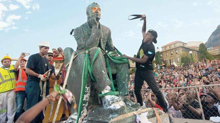 Entkolonialisierung. Studenten attackieren die Statue des britischen Politikers und Bergbaumagnaten Cecil Rhodes auf dem Gelände der Universität von Kapstadt. Nach monatelangen Protesten wurde das Standbild am 9. April 2015 entfernt.