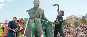 Entkolonialisierung. Studenten attackieren die Statue des britischen Politikers und Bergbaumagnaten Cecil Rhodes auf dem Gelände der Universität von Kapstadt. Nach monatelangen Protesten wurde das Standbild am 9. April 2015 entfernt.