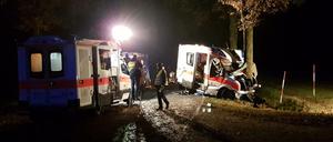 Rettungskräfte stehen am Donnerstag an einer Unfallstelle bei Langen (Niedersachsen), an der ein Rettungswagen gegen einen Straßenbaum geprallt ist.