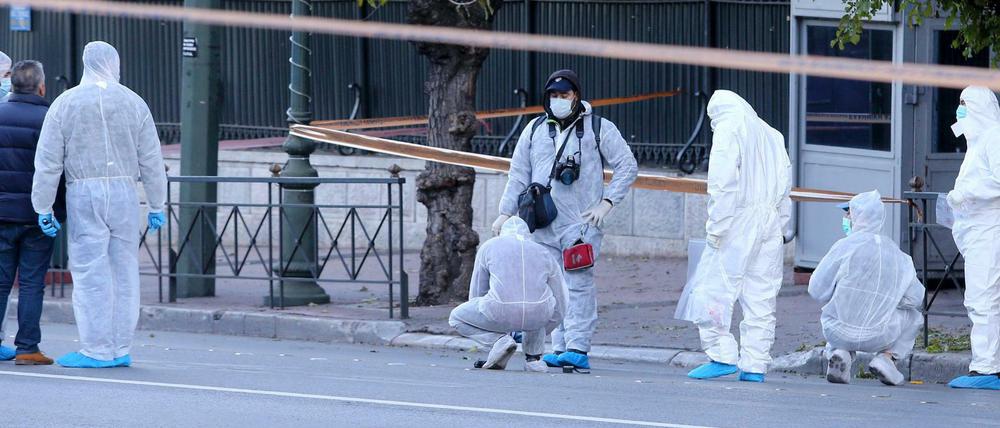 Polizisten in Athen untersuchen die explodierte Handgranate an der französischen Botschaft.