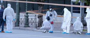 Polizisten in Athen untersuchen die explodierte Handgranate an der französischen Botschaft.