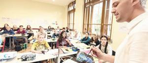 Mit Tablet vor der Klasse. Lehrer attestieren sich selbst gute Kompetenzen beim Umgang mit digitalen Medien. Experten zweifeln diese Selbsteinschätzung allerdings an. 