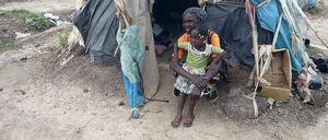 Hütte aus Plastikabfällen. Mama Rebecca lebt seit 2013 auf dem Flughafen der Hauptstadt Bangui. Mit einer ihrer Enkelinnen sitzt sie vor ihrer Behausung.