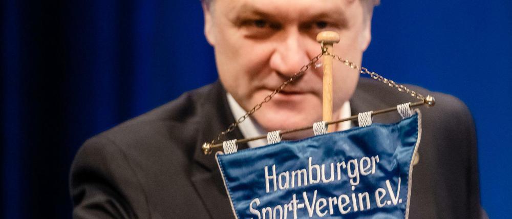 Vorstandschef Dietmar Beiersdorfer greift nach einem HSV Wimpel. 