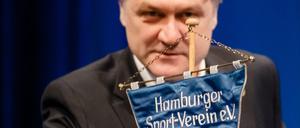 Vorstandschef Dietmar Beiersdorfer greift nach einem HSV Wimpel. 