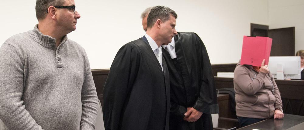 Die Angeklagten Wilfried W.(l) und Angelika W. (r, mit Aktenordner vor dem Gesicht) stehen in Paderborn vor Gericht.