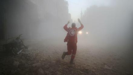 Helfer vom Syrischen Roten Halbmond suchen in dem von Rebellen kontrollierten Ort Douma nach Opfern eines Luftangriffs.