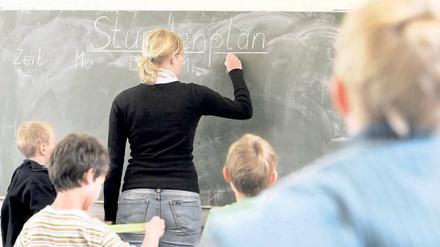 Was steht an? Eine Lehrerin schreibt einen Stundenplan. 