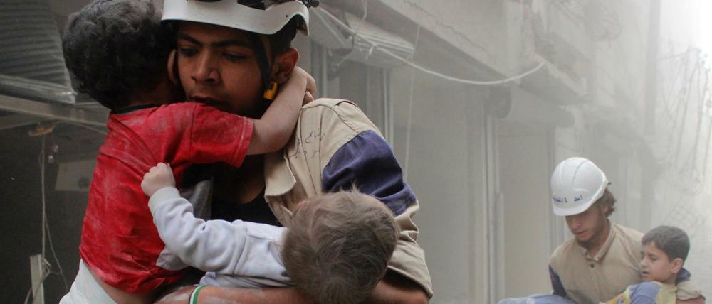 Nach einem Luftangriff: Syrische Weißhelme bergen im Jahr 2014 Kinder aus den Trümmern.