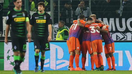 Manchesters Spieler jubeln nach dem 1:1. Links Lars Stindl und Tobias Strobl (2.v.l) von Mönchengladbach.