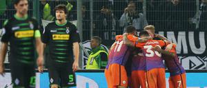Manchesters Spieler jubeln nach dem 1:1. Links Lars Stindl und Tobias Strobl (2.v.l) von Mönchengladbach.