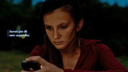 "Ich hätte heute nicht kommen sollen". Das Mädchen (Naomie Vogt-Roby) liest die Nachricht des Jungen auf ihrem Handy. 