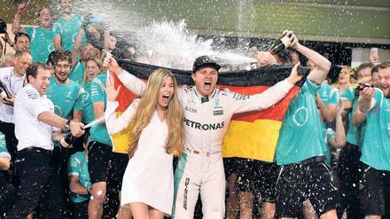 Regen nach dem Rennen. Nico Rosberg feiert mit seiner Frau Vivian den Triumph von Abu Dhabi.