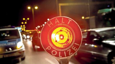 Ein Polizist stoppt am 18.09.2014 in Berlin auf der Autobahn 100 unweit der Aus- und Einfahrt Beusselstraße mit seiner Kelle einen Pkw. Beim bundesweiten Blitzer-Marathon geht die Polizei in der Hauptstadt an verschiedenen Kontrollstellen gegen Raser vor. Foto: Paul Zinken/dpa +++(c) dpa - Bildfunk+++