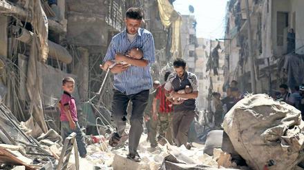 Das nackte Leben. Nach einem Bombenangriff versuchen Männer in Aleppo, Säuglinge in Sicherheit zu bringen. 