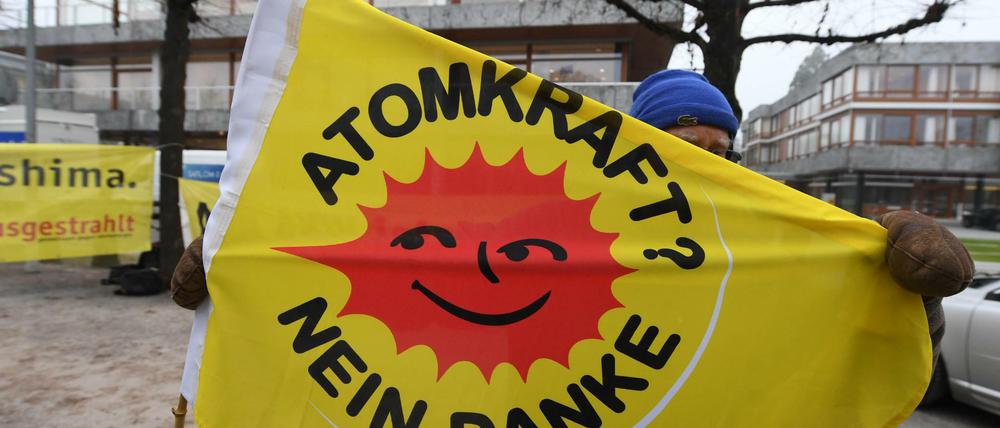 Vor dem Bundesverfassungsgericht in Karlsruhe hält ein Mann eine Anti-Atomkraft-Fahne hoch.