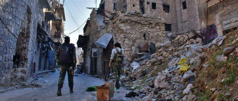 Soldaten der syrischen Regierung laufen durch die fast völlig zerstörte Altstadt von Aleppo.