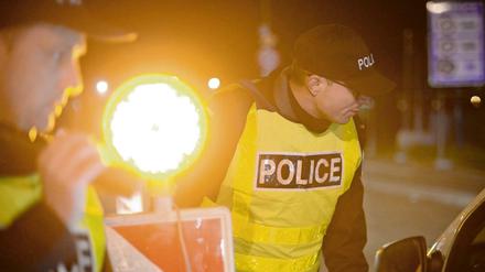 Beamte der Police Nationale kontrollieren in Straßburg (Frankreich) an der Europabrücke in der Nacht Fahrzeuge.