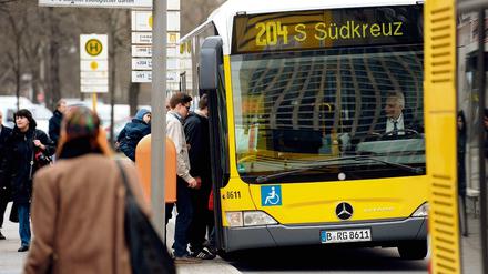 Passanten steigen in Berlin in einen Bus.