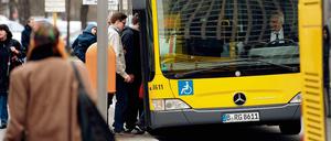 Passanten steigen in Berlin in einen Bus.