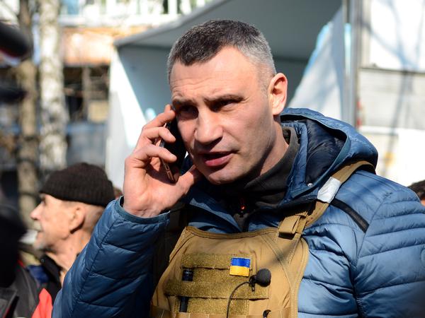 Kiews Bürgermeister Witali Klitschko telefoniert am 15. März 2022 vor einem von den russischen Truppen beschossenen Wohnhaus.