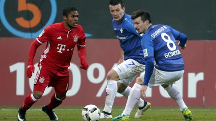 Später wurde er zum Matchwinner. Der Münchener Douglas Costa (l.) im Zweikampf mit Jerome Gondorf (r.) und Artem Fedetsky aus Darmstadt.