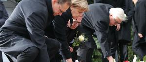 Bundeskanzlerin Angela Merkel (CDU) gedenkt am 20.12.2016 am Ort des Anschlages in Berlin der Opfer zusammen mit Bundesinnenminister Thomas de Maizière (CDU), Bundesaußenminister Frank-Walter Steinmeier (SPD, r) und mit dem Regierenden Bürgermeister von Berlin, Michael Müller (SPD, l).