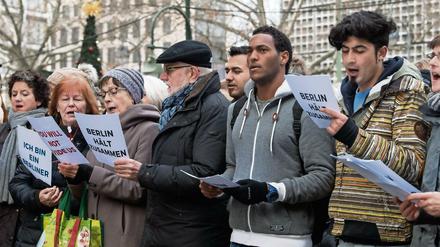 Zusammen stehen: Der "Begegnungschor", ein Flüchtlingschor aus Berlin, und der "Everybody Can Sing Chor" der Berliner Gedächtniskirche singen zusammen am 21. Dezember in der Nähe des Anschlagsorts auf dem Weihnachtsmarkt am Breitscheidplatz in Berlin. 