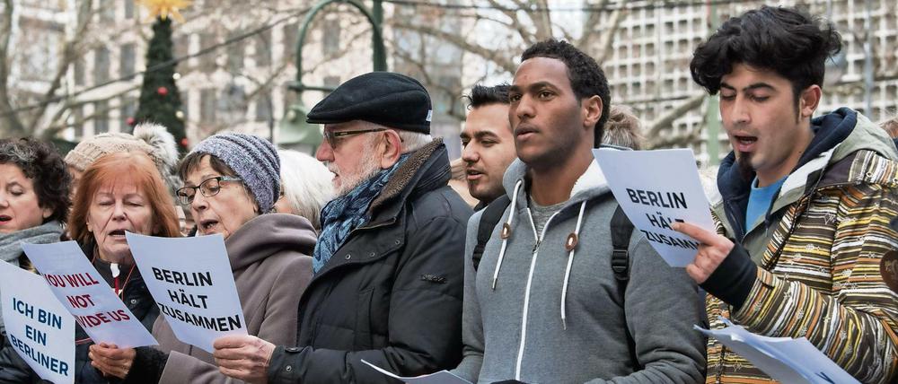 Zusammen stehen: Der "Begegnungschor", ein Flüchtlingschor aus Berlin, und der "Everybody Can Sing Chor" der Berliner Gedächtniskirche singen zusammen am 21. Dezember in der Nähe des Anschlagsorts auf dem Weihnachtsmarkt am Breitscheidplatz in Berlin.