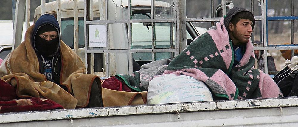 Bewohner von Ost-Aleppo kauern auf der Ladefläche eines Lastwagens, der sie ins Rebellengebiet bringt.