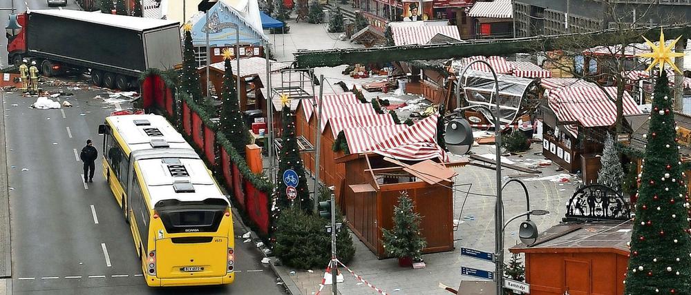  Der Tatort am Breitscheidplatz in Berlin. Auf dem Foto sieht man, wie der Sattelauflieger des LKW von einer roten Zugmaschine abgeschleppt wird. 