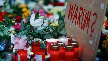 An der Gedächtniskirche legen Menschen Blumen und Lichter.