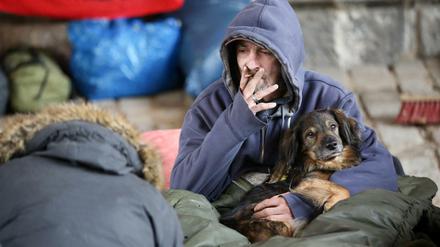 Der obdachlose Slowake Stano sitzt ei Temperaturen um den Gefrierpunkt mit seinem Hund Mob zwischen Decken und Matratzen unter einer Brücke an der Helgoländer Allee in Hamburg.